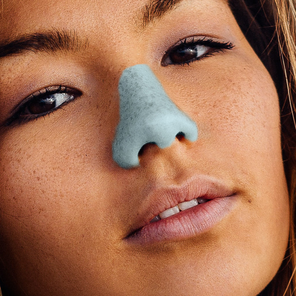 Close up of female model wearing blue Noz sunscreen on nose